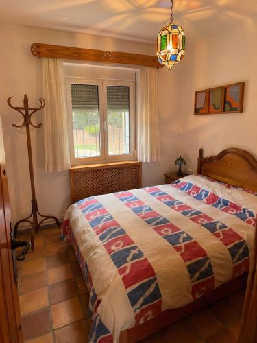 a bedroom with a bed with a colorful quilt at Casa Rural Mandala Riópar in Riópar