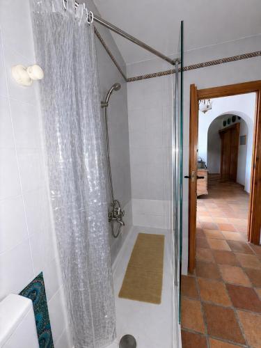 a shower with a shower curtain in a bathroom at Casa Rural Mandala Riópar in Riópar