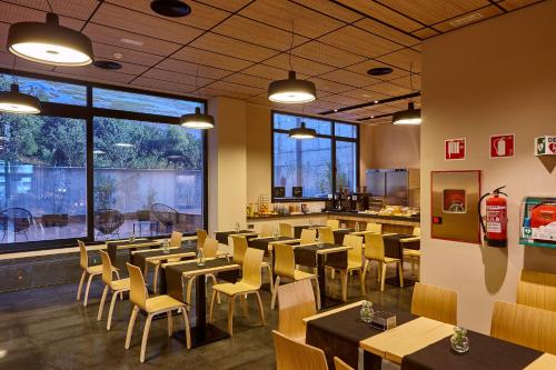 a restaurant with tables and chairs and a bar at Hotel Bilbao Plaza in Bilbao