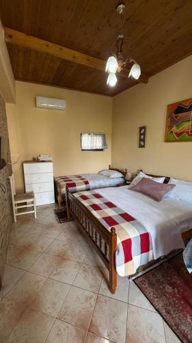 a bedroom with two beds and a wooden ceiling at Villa Gersina Golem in Golem