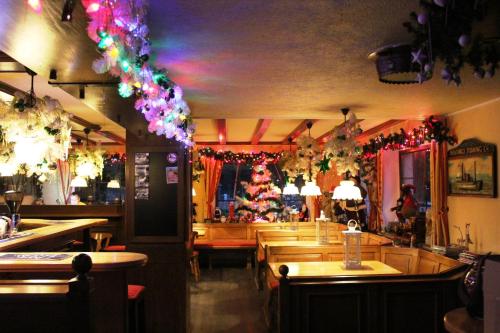 a restaurant with christmas decorations and a bar with wooden tables at Hotel Heiderhof in Obersteinebach