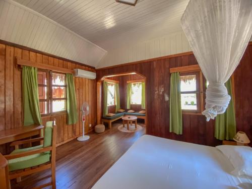 a bedroom with a bed and green curtains in it at Le Renala Morondava in Morondava