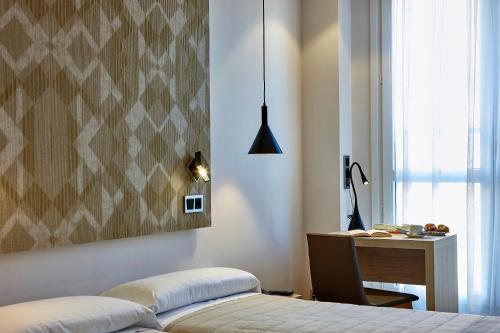 a bedroom with a bed and a desk and a deskablish at Hotel Bilbao Plaza in Bilbao