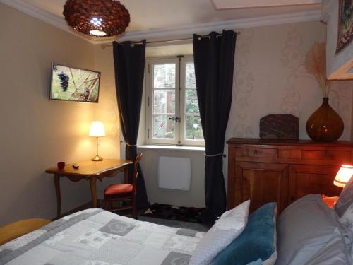 a bedroom with a bed and a window at La Maison De Béatrice in Murat
