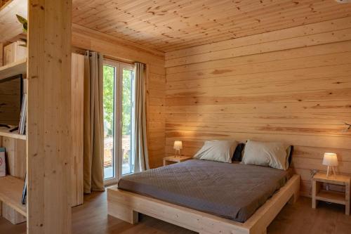 a bedroom with a bed in a wooden cabin at Redon Marias House 1 in Ágios Matthaíos