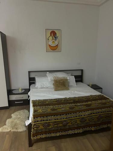 a bedroom with a large bed with two night stands at Zahra Résidence in Rufisque
