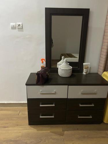 a black and white dresser with a mirror on it at Zahra Résidence in Rufisque