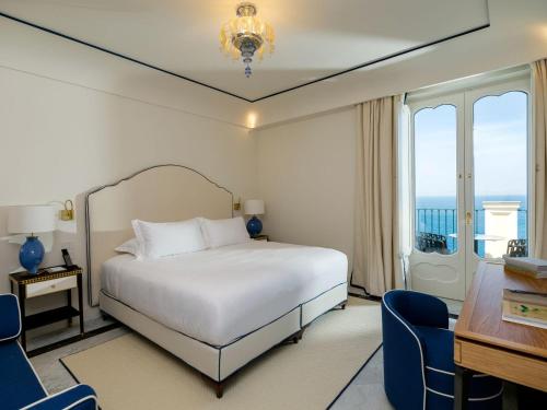 a bedroom with a bed and a table and chairs at Hotel du Tasso Sorrento in Sorrento