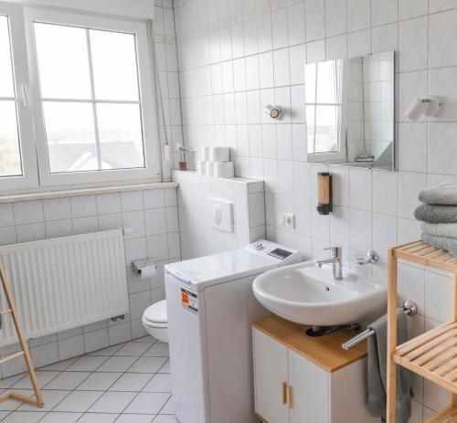 a white bathroom with a sink and a toilet at Ferienwohnung Weigl Komfort in Nittenau