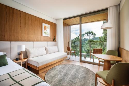 a hotel room with a bed and a couch at Hotel Vila Inglesa in Campos do Jordão
