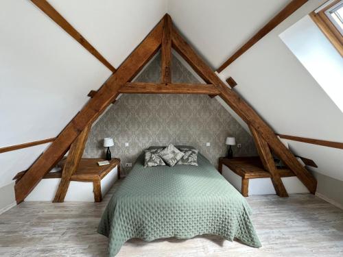 a bedroom with a green bed in a attic at Gîte La Nuit Étoilée chez Champagne Mathelin in Mareuil-le-Port