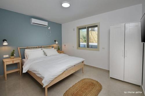 a bedroom with a large bed and a window at MeravSuite in Migdal