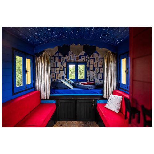 a room with two red seats in a train room at La roulotte MAGIC ! des Grillots in Beaulon