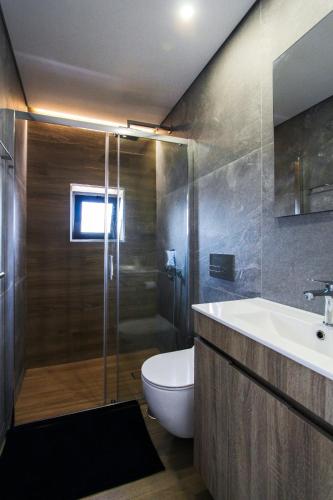 a bathroom with a toilet and a sink and a shower at Private Beach Villa in Vila Nova de Gaia