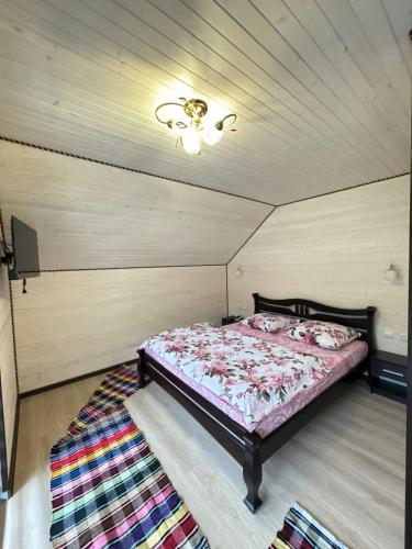 a bedroom with a bed in a room with a ceiling at Котедж у Софійки in Synevyrsʼka Polyana