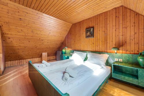 a large bed in a room with wooden walls at Erlaufsee Estate by Landluft in Mitterbach