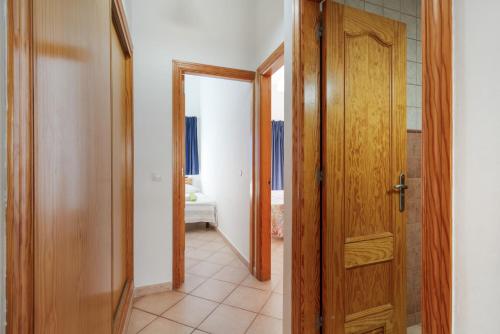 a hallway with a wooden door and a room at Apartamento Luminoso Lagos Cotillo in El Cotillo