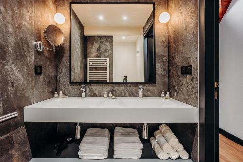 a bathroom with a sink and a mirror at ISKÖ CHALETS-HÖTEL, Col d'Aubisque in Gourette