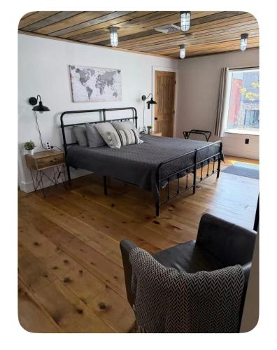 a bedroom with a bed and a chair in it at Sleep at Simplicity in Massena