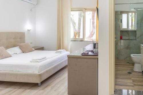 a bedroom with a bed and a bathroom with a shower at Le Monde 2 in Borsh