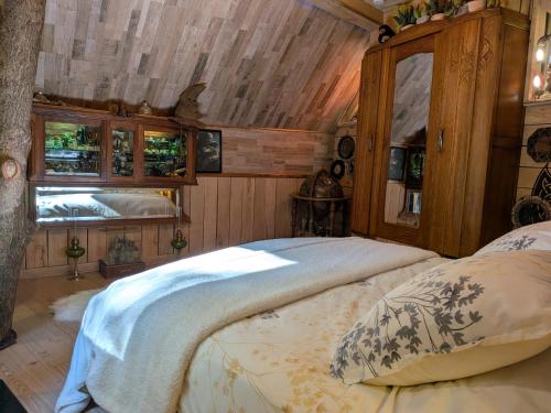 a bedroom with a bed and a wooden ceiling at Au Bois Dormant B&B in Tillé