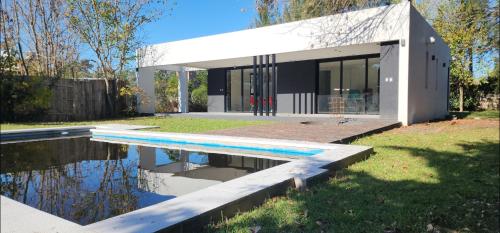 a house with a swimming pool in front of it at Casa Quinta El Rodeo in La Plata