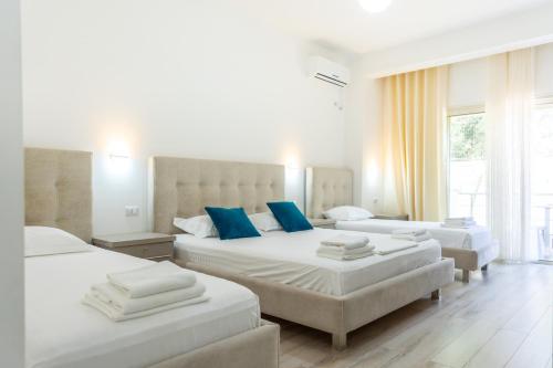 a bedroom with three beds with blue pillows at Le Monde 2 in Borsh