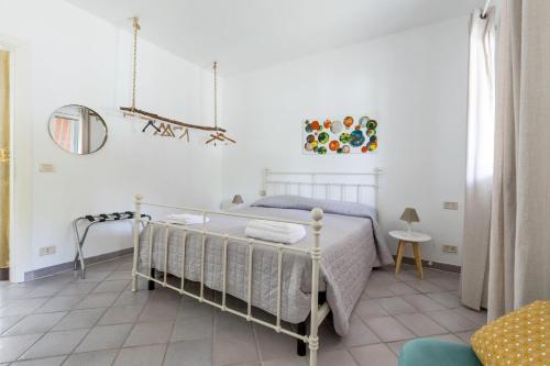 a white bedroom with a bed and a mirror at Villa Thalissa by Perle di Puglia in Taranto