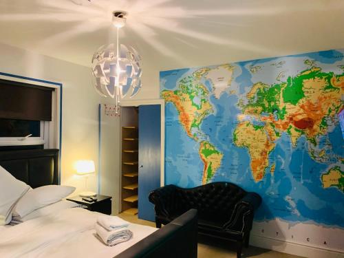 a bedroom with a map of the world on the wall at Blue Room in Ifield