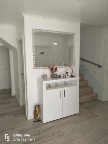 a white bathroom with a sink and a mirror at Paradise Breeze in Carvalhal