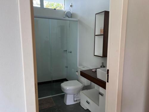 a bathroom with a toilet and a sink and a mirror at Vistas de Gravatá in Gravatal