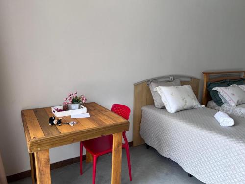 a bedroom with a wooden desk and a bed and a table and chairs at Vistas de Gravatá in Gravatal