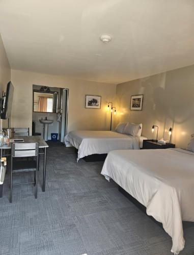 a hotel room with two beds and a desk at Mountain Creek Tavern in Mount Holly Springs