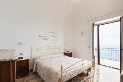 a bedroom with a bed and a large window at La casa del sole in Conca dei Marini