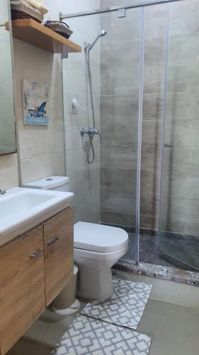 a bathroom with a shower and a toilet and a sink at HEAVEN BEACH in Sidi Rahal