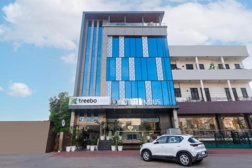 a white car parked in front of a building at Treebo Indus in Jaipur