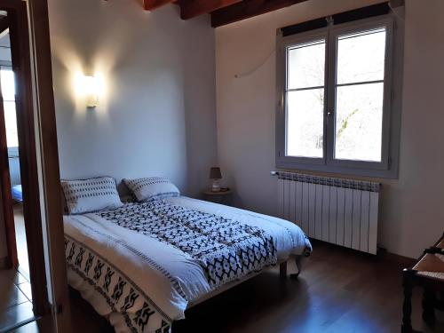 a bedroom with a bed and a window at Gîte Du Mas De La Font in Meyrueis