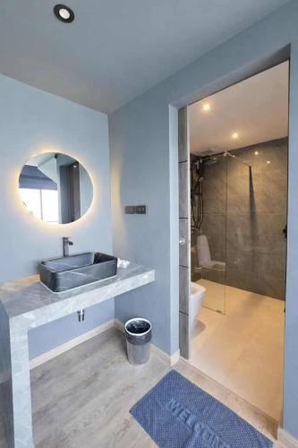a bathroom with a sink and a glass shower at Beachside Hotel H8 in Ban Nong Si Tong