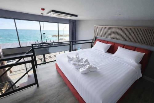a bedroom with a bed with a view of the ocean at Beachside Hotel H8 in Ban Nong Si Tong