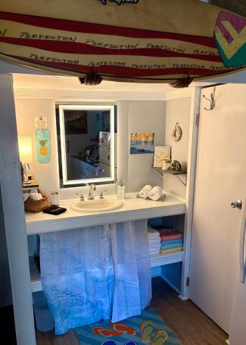 a bathroom with a sink and a mirror at Romantic Beach Style Cottage close to everything! in Whitehouse Plantation