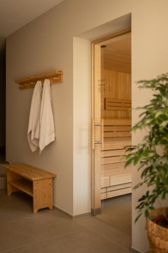 a bathroom with a towel hanging on a wall at Vitalpina Hotel Schulerhof in Plaus