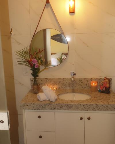 a bathroom with a sink and a mirror at Hospedagem Arte na Cura in Guarapari