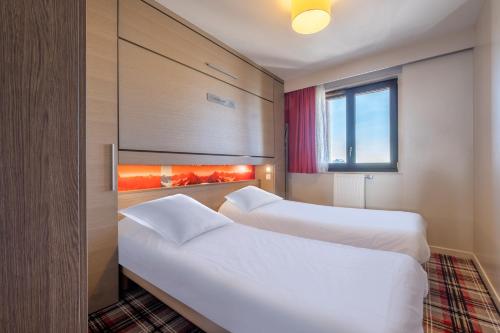a hotel room with two beds and a window at Résidence Pierre & Vacances Atria-Crozats in Avoriaz