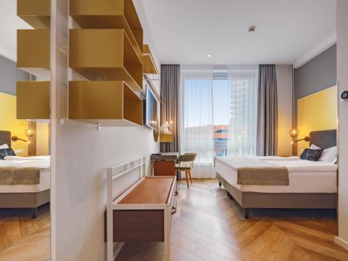 a hotel room with two beds and a desk at HIAMO Hotel Hamburg-Bergedorf in Hamburg