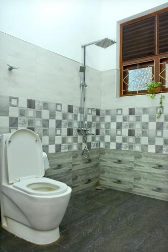 a bathroom with a toilet and a window at Hamilton View in Negombo