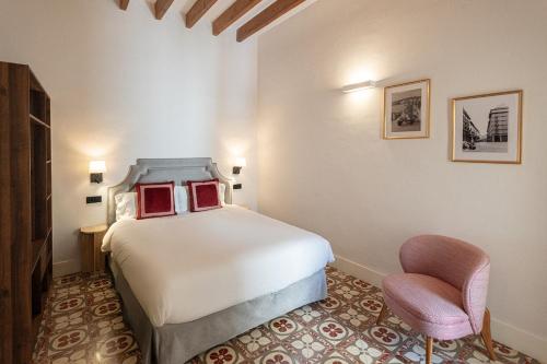 a hotel room with a bed and a chair at Sa Pobla Rooms Ex Flor de Mandarina in Sa Pobla