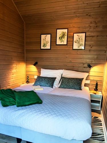 a large bed in a room with wooden walls at Euforia Górzno - nowoczesne domki nad jeziorem z sauną, balią, jacuzzi in Górzno