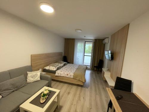 a living room with a bed and a couch at Apartmán Flower in Podhájska