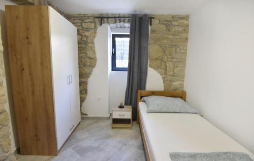 a small room with a bed and a window at Comfortable vacation retreat with parking in Plovanija