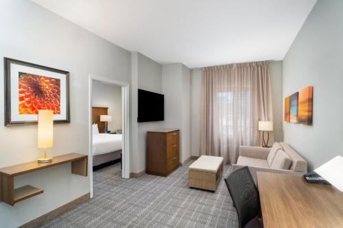 a hotel room with a couch and a bed at Staybridge Suites Augusta by IHG in Augusta